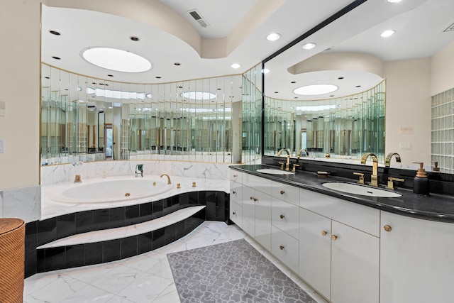 bathroom featuring tiled tub and vanity