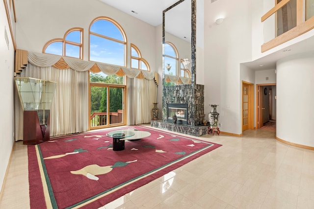 unfurnished living room featuring a high ceiling and a high end fireplace