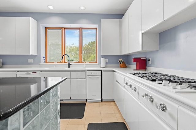 kitchen featuring white cabinets, white appliances, light tile patterned floors, and sink