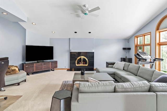 carpeted living room with a fireplace, vaulted ceiling, and ceiling fan