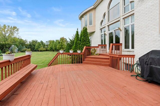 wooden deck featuring grilling area and a yard