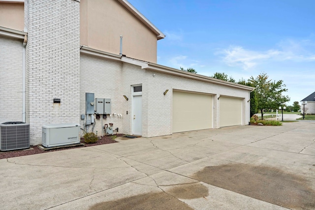 exterior space featuring central air condition unit and a garage