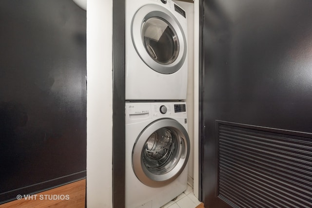 washroom with light tile patterned floors and stacked washer and dryer