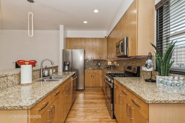 kitchen with light hardwood / wood-style floors, tasteful backsplash, light stone countertops, stainless steel appliances, and sink