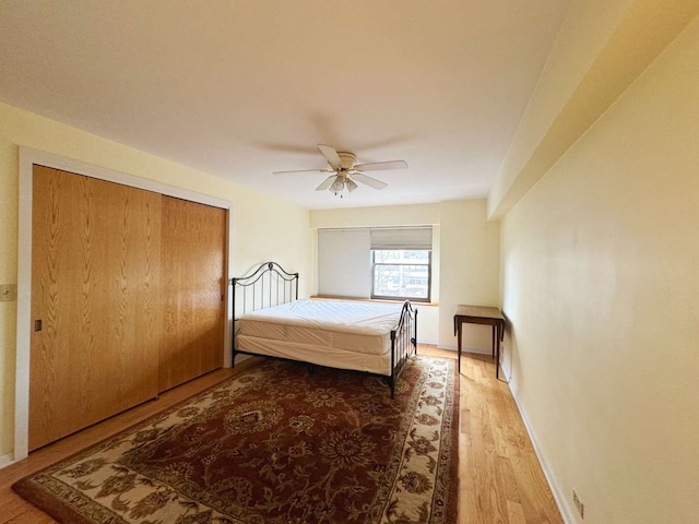 bedroom featuring wood-type flooring, ceiling fan, and a closet