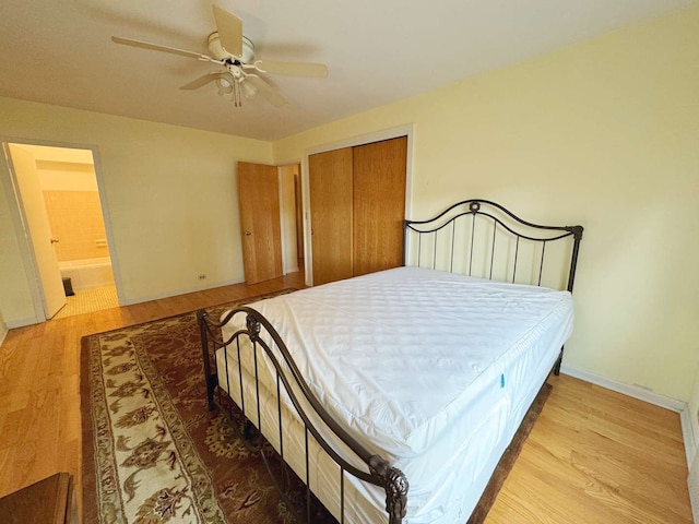 bedroom with a closet, ensuite bath, ceiling fan, and light wood-type flooring