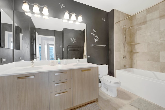 full bathroom with double sink vanity, tiled shower / bath, toilet, and tile floors