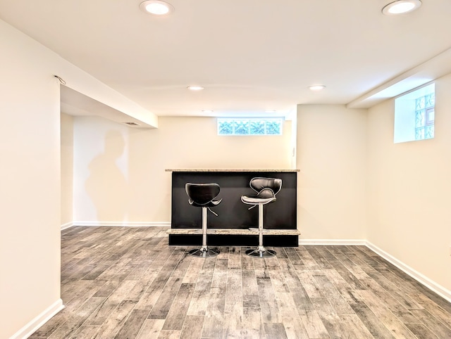 basement featuring wood-type flooring and bar