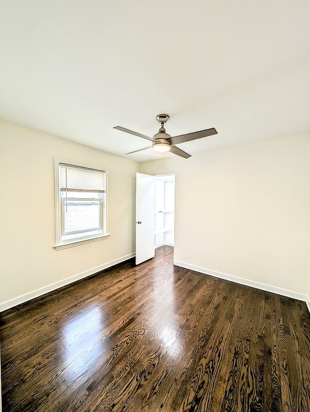 spare room with ceiling fan and dark wood-type flooring