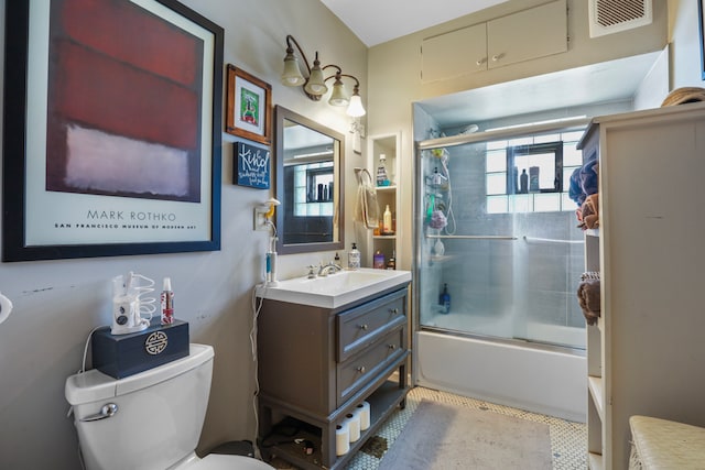 full bathroom with tile flooring, toilet, large vanity, and bath / shower combo with glass door