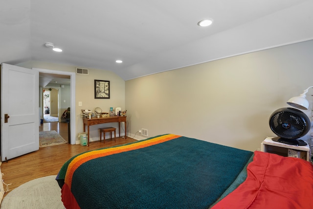 bedroom with hardwood / wood-style floors and lofted ceiling