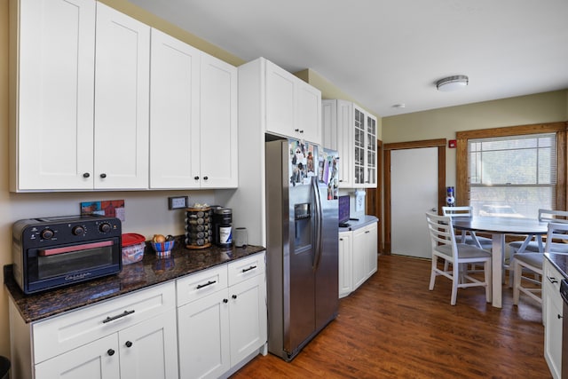 kitchen with white cabinets, dark stone countertops, stainless steel fridge, and dark hardwood / wood-style floors