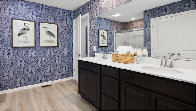 bathroom with double vanity and wood-type flooring