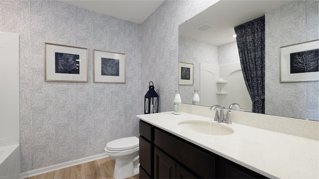 full bathroom featuring hardwood / wood-style floors, oversized vanity,  shower combination, and toilet