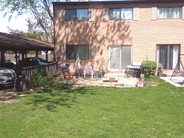 rear view of house featuring a patio and a lawn