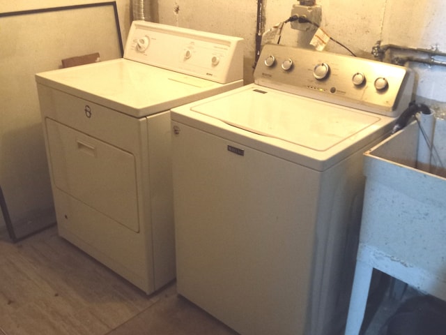 laundry room with wood-type flooring and washing machine and dryer