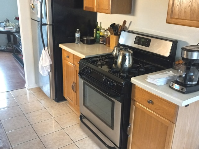 kitchen with stainless steel appliances and light tile flooring