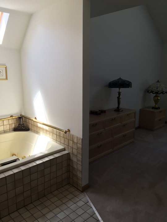 bathroom with vaulted ceiling with skylight and tiled bath