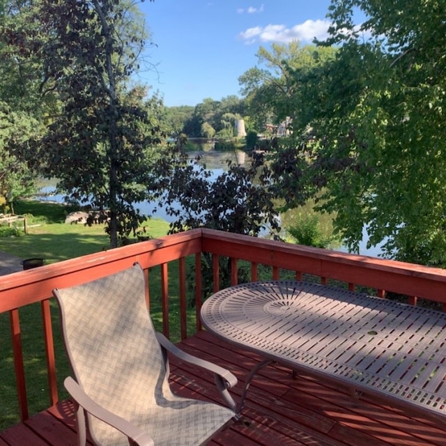 deck with a lawn and a water view