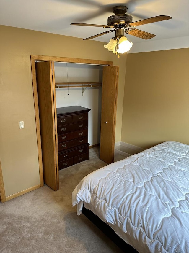 carpeted bedroom featuring ceiling fan and a closet