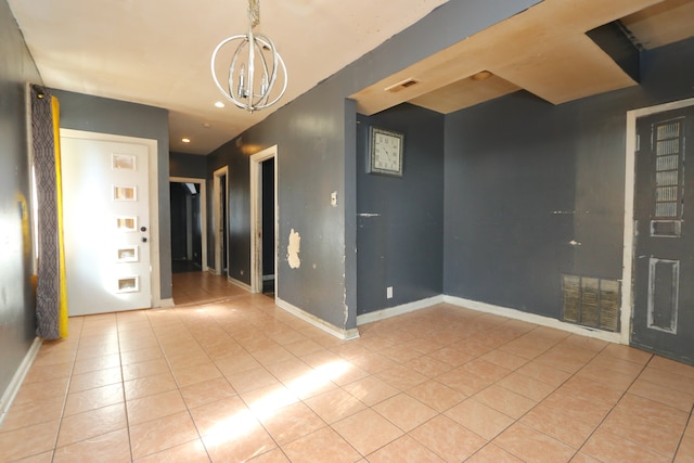 tiled empty room with a chandelier