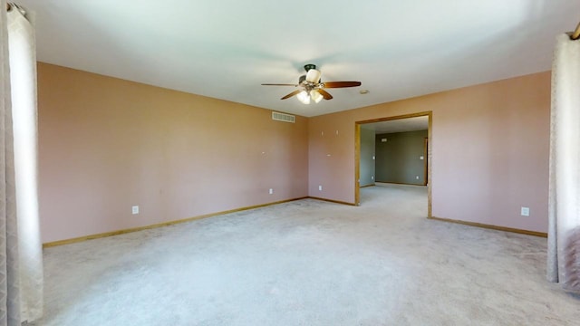 empty room with light carpet, baseboards, visible vents, and a ceiling fan