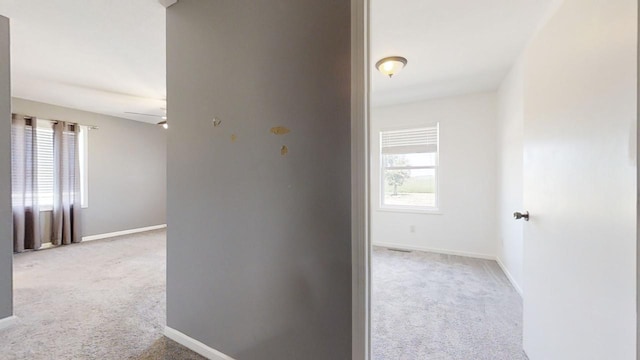 corridor with light carpet and baseboards