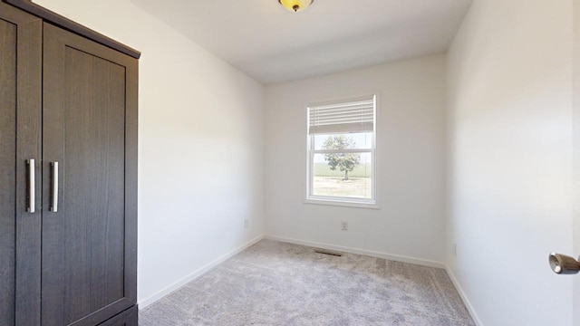 unfurnished bedroom with light carpet, visible vents, and baseboards