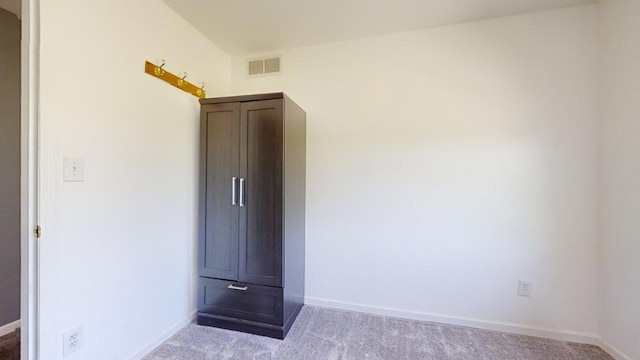 unfurnished bedroom featuring light carpet, baseboards, and visible vents