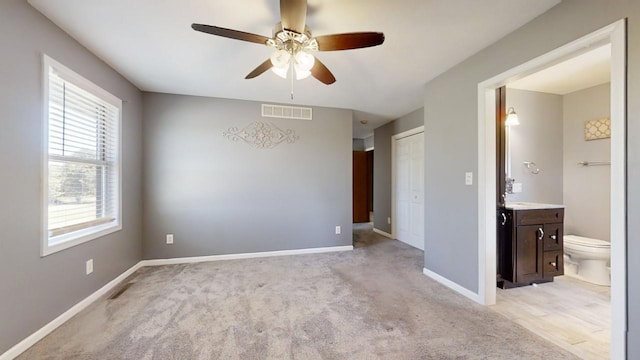 unfurnished room featuring ceiling fan, light colored carpet, visible vents, and baseboards