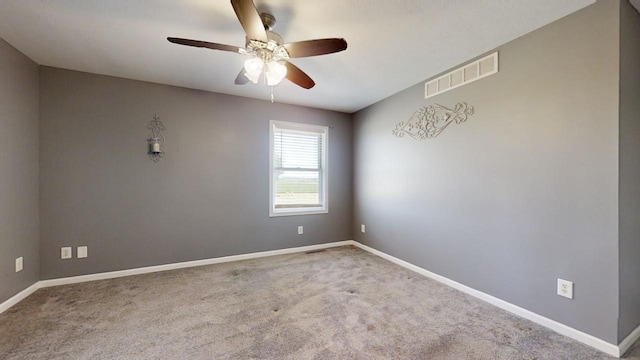 carpeted spare room with ceiling fan, visible vents, and baseboards