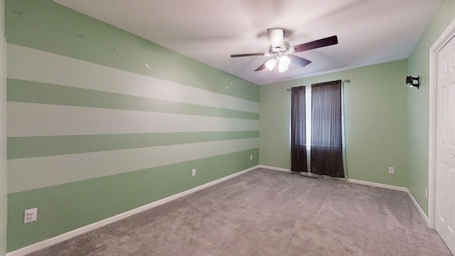 empty room with baseboards, ceiling fan, and light colored carpet