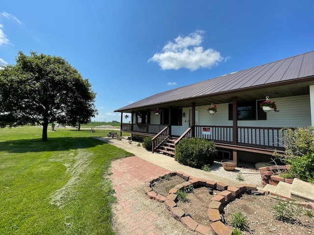 view of front of home with covered porch, metal roof, and a front lawn