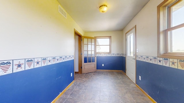 unfurnished room with dark tile patterned floors and visible vents