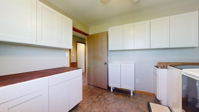 laundry room with cabinet space, baseboards, stone finish floor, and separate washer and dryer