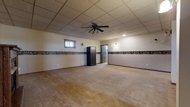 basement with a paneled ceiling, carpet, and a fireplace