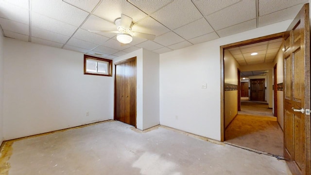 interior space featuring a ceiling fan and a drop ceiling