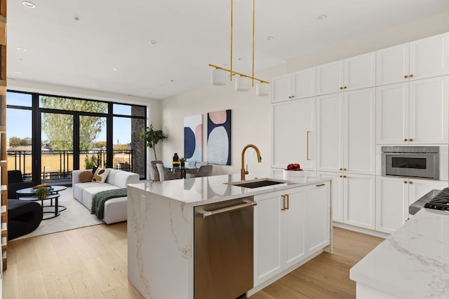 kitchen with white cabinets, dishwasher, light stone countertops, and sink