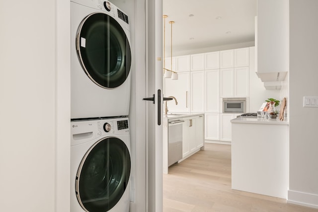 laundry room featuring light hardwood / wood-style floors, sink, and stacked washer and dryer