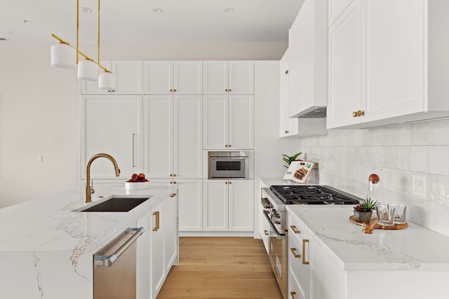 kitchen with white cabinets, pendant lighting, stainless steel appliances, and sink