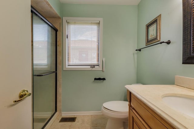 bathroom with a shower with door, toilet, tile floors, and vanity