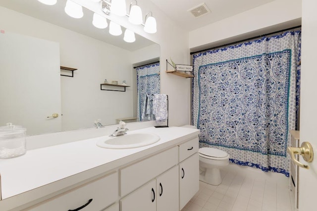 bathroom with toilet, tile flooring, and vanity