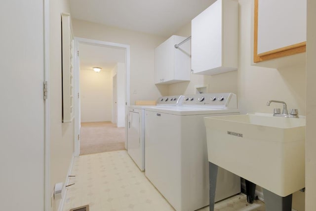 laundry room with light colored carpet, cabinets, sink, and washer and dryer