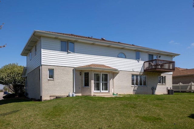 rear view of property with a balcony, a yard, and central air condition unit