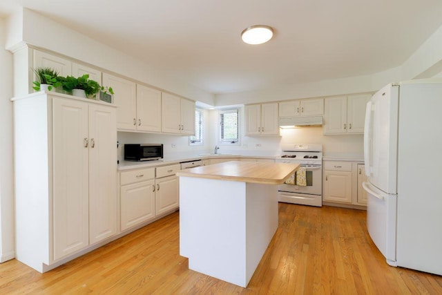 kitchen with a kitchen island, white cabinetry, light hardwood / wood-style flooring, and white appliances