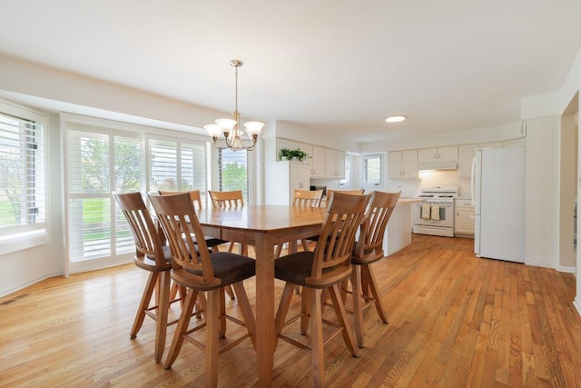 dining room featuring a wealth of natural light, light hardwood / wood-style floors, and a notable chandelier