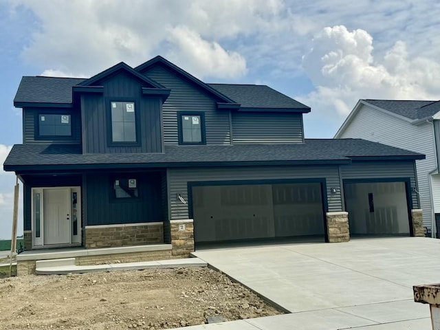 craftsman house featuring a shingled roof, covered porch, stone siding, board and batten siding, and concrete driveway