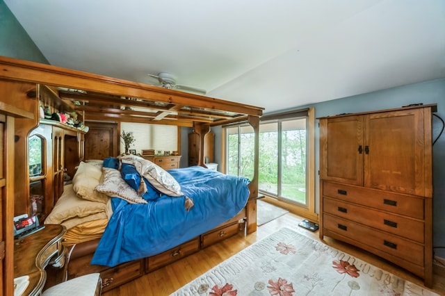 bedroom with vaulted ceiling, light hardwood / wood-style floors, and access to exterior