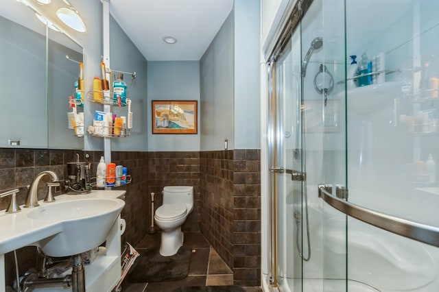 bathroom with tile floors, tile walls, toilet, and walk in shower