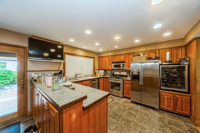 kitchen with sink, stainless steel appliances, tile floors, and kitchen peninsula